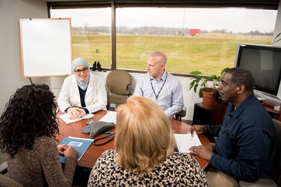 Cherara talks to a group pf people around a round table