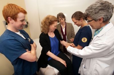 Dr. Ellen Smith supervises students giving a physical pain assessment