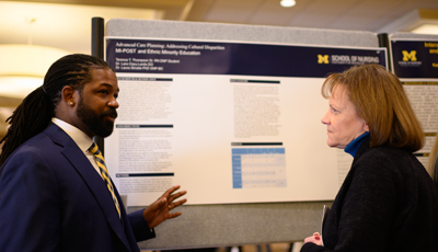 Student presenting a poster to an interested faculty