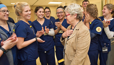 Sara Rothschild in front of a group of nursing students showing appreciation.