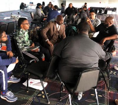 Group of people sitting in a circle at the men's community health forum