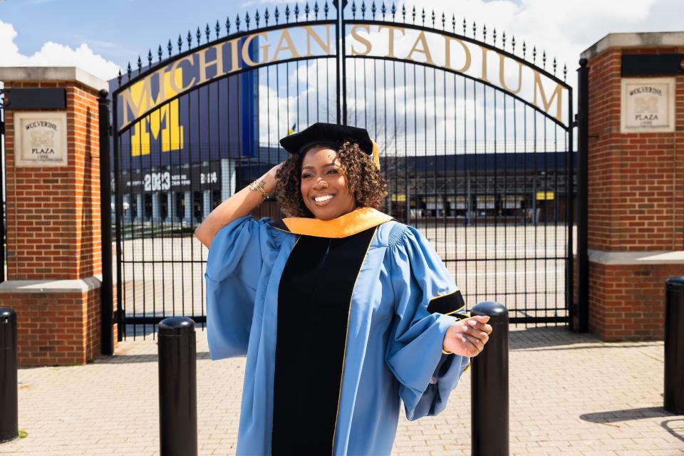 faith lucas standing in front of the big house during graduation day