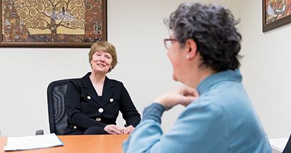 U-M School of Nursing Dean Patricia D. Hurn talk across the table to faculty member Megan Eagle