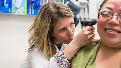 Nurse examines patient with otoscope