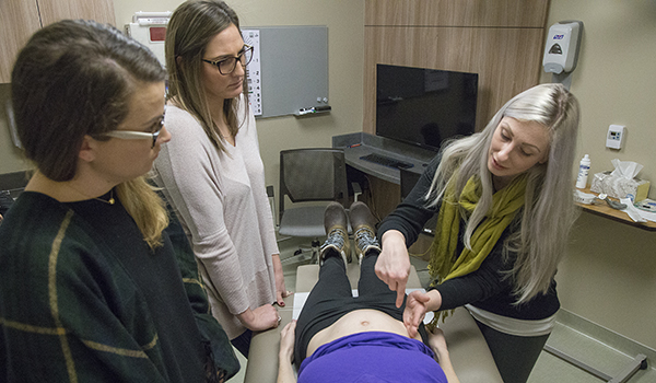 pregnant volunteer is examined by three students