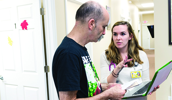 Student and instructor discuss work on a computer