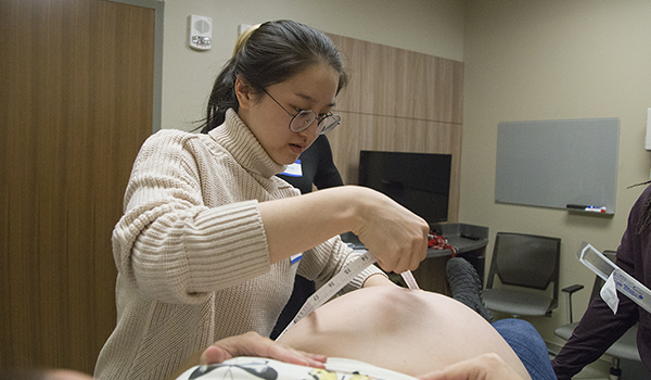 pregnant person is examined by student