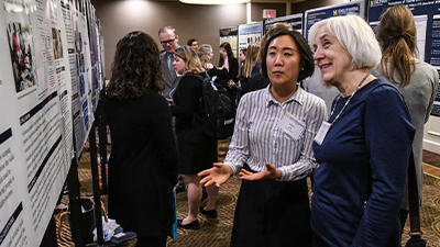 Ph.D. student discussing research poster with professor