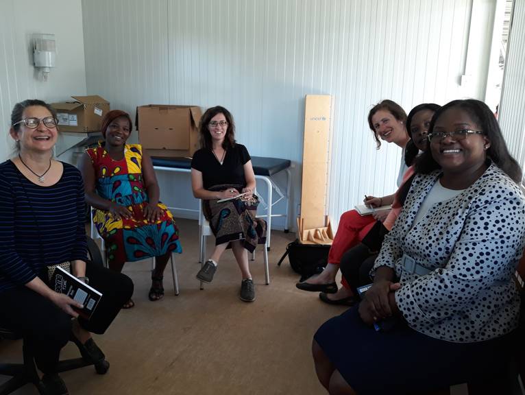 U-M School of Nursing faculty sitting in a circle with African faculty members during a meeting in Africa.