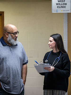 At the West Willow Clinic a researcher with a clipboard talking to a respondent