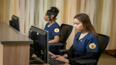 U-M School of Nursing student holds a clipboard while talking to a patient