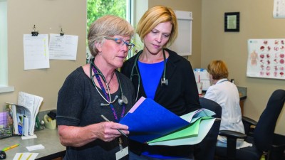 Laura Gultekin and Barbara Brush review paperwork together