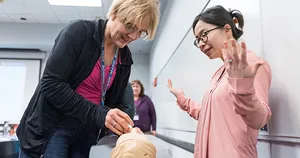 Faculty demonstrating a procedure on a manikin