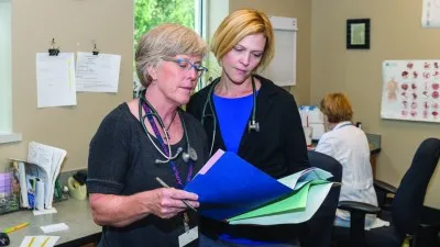 Laura Gultekin and Barbara Brush review paperwork together
