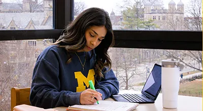Student studying by highlighting text in her notes
